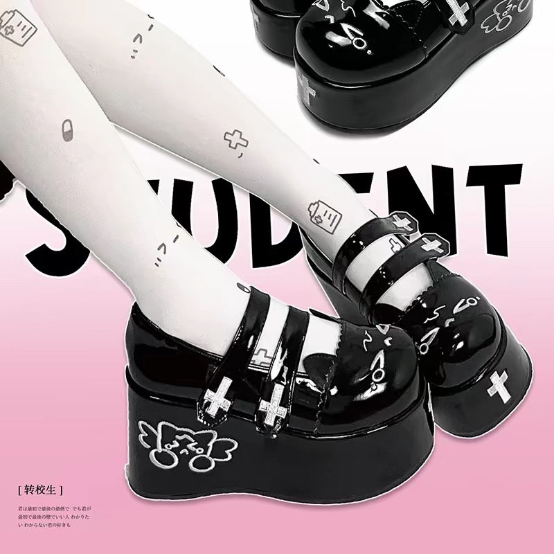 Black platform shoes with cross straps and cat graphic