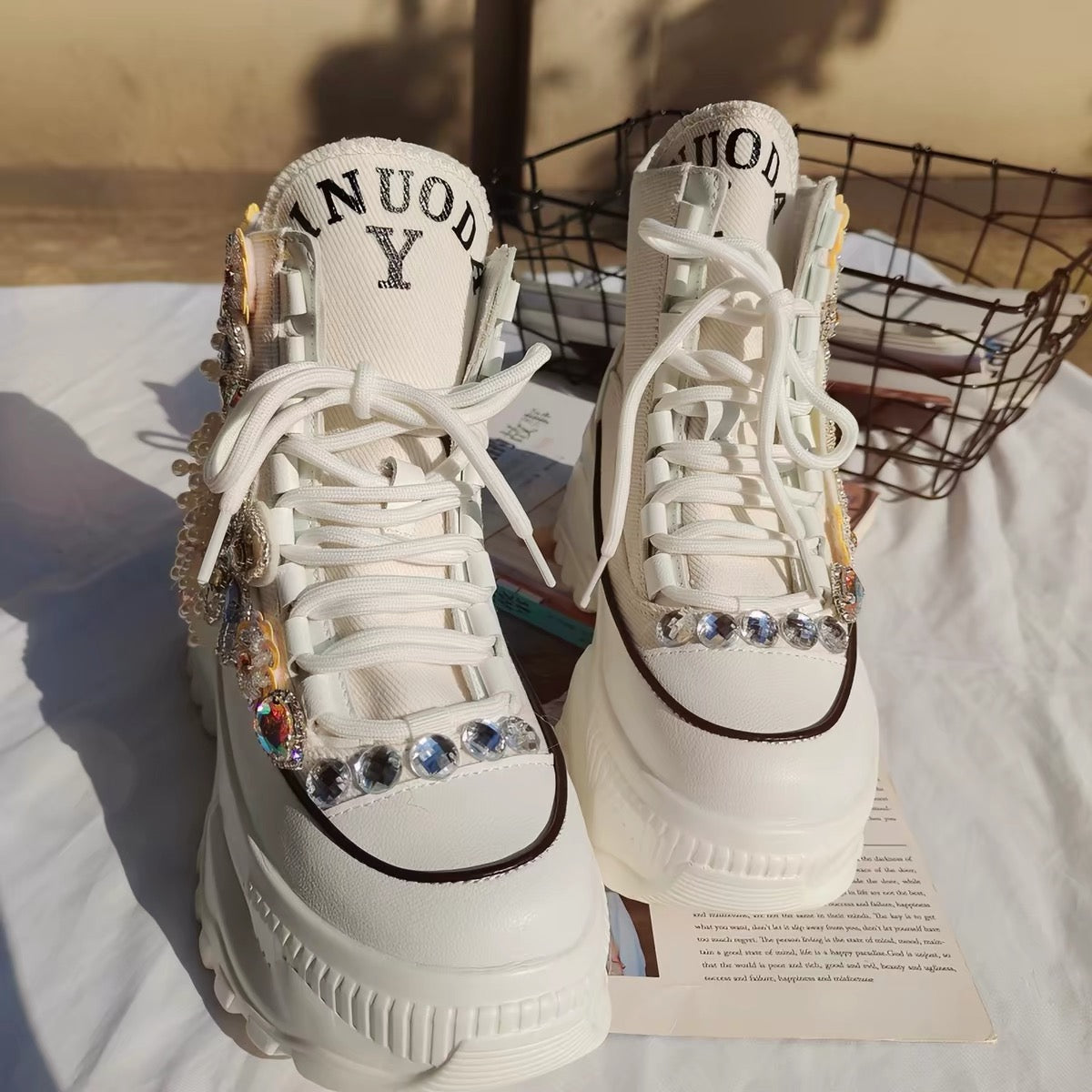 Front view of white embellished platform shoes with rhinestones
