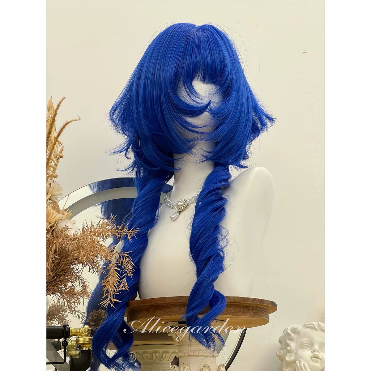 Cobalt blue layered wig front view with full bangs and curled face framing pieces