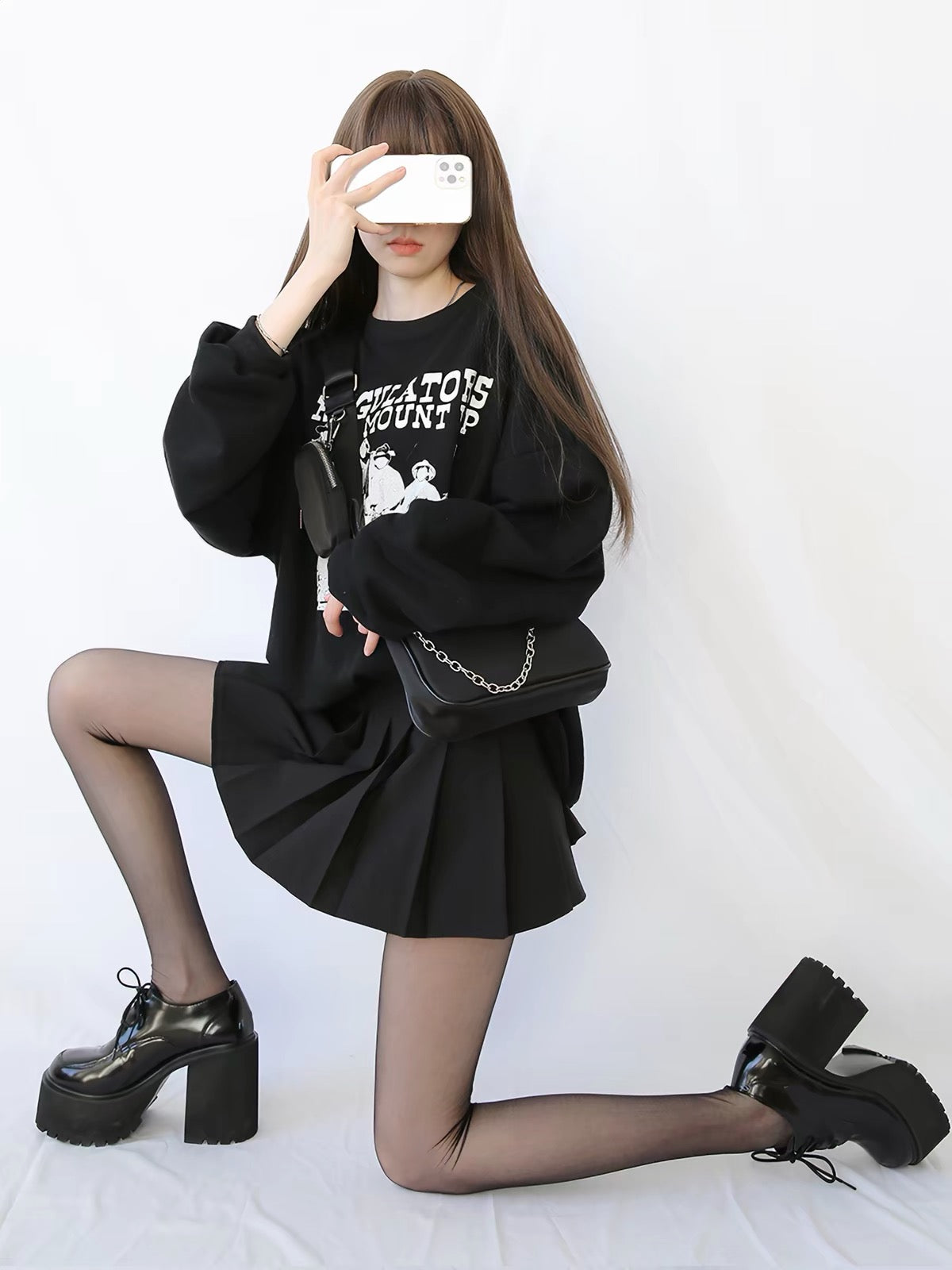 Black chunky platform lace-up oxford heels styled with black pleated skirt