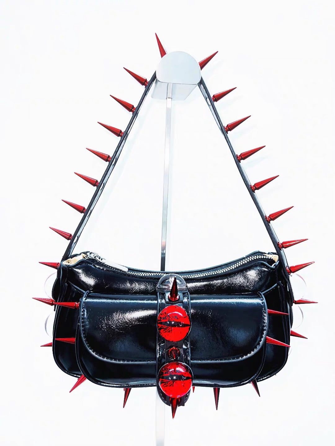 Black patent shoulder bag with red spikes and red kiss hardware