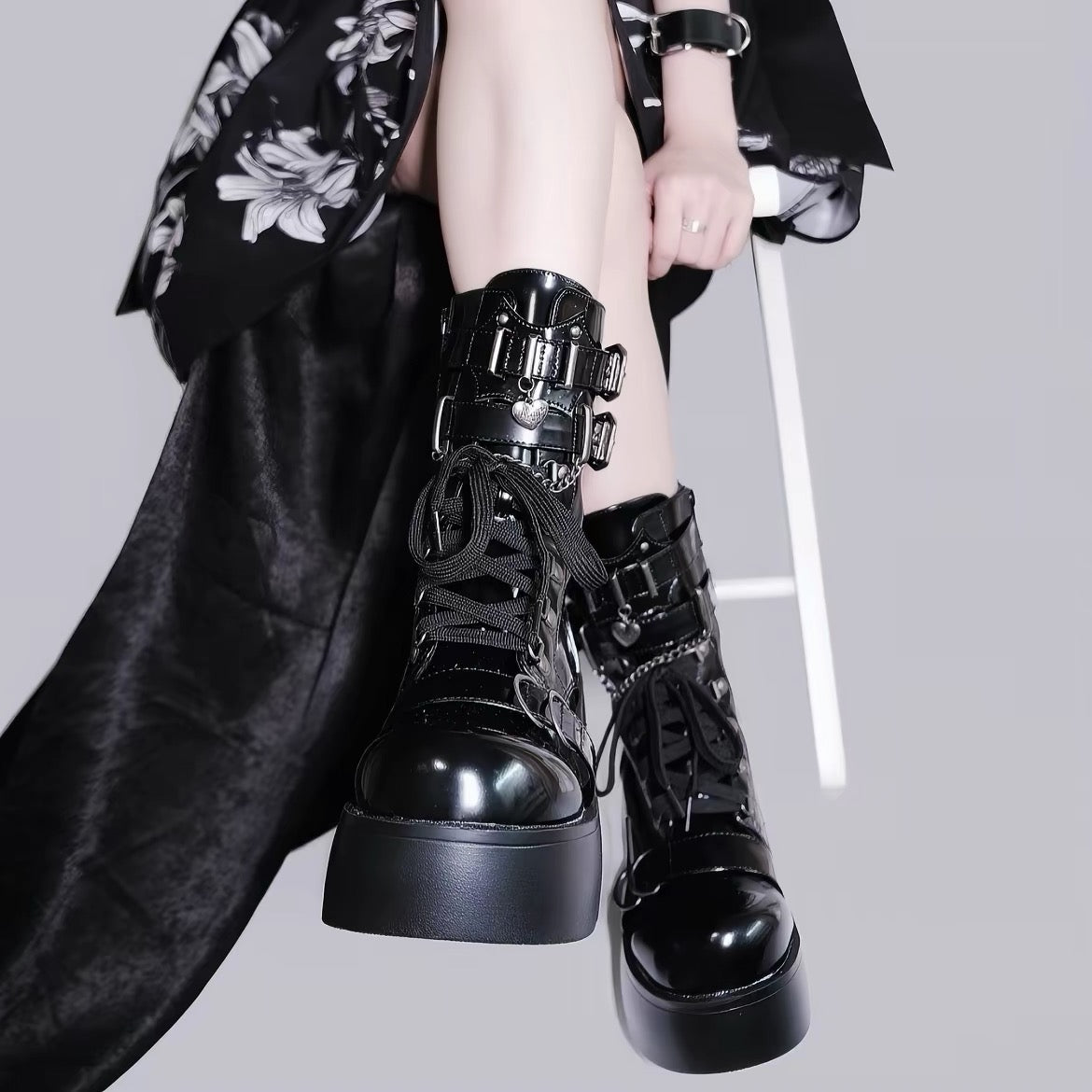 Black platform boots with buckle and heart charm details