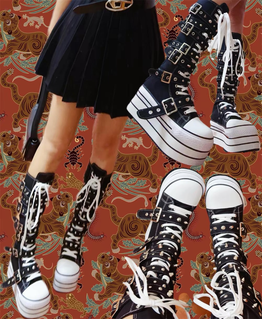 Black and white platform boots with white laces, silver studs and buckle straps