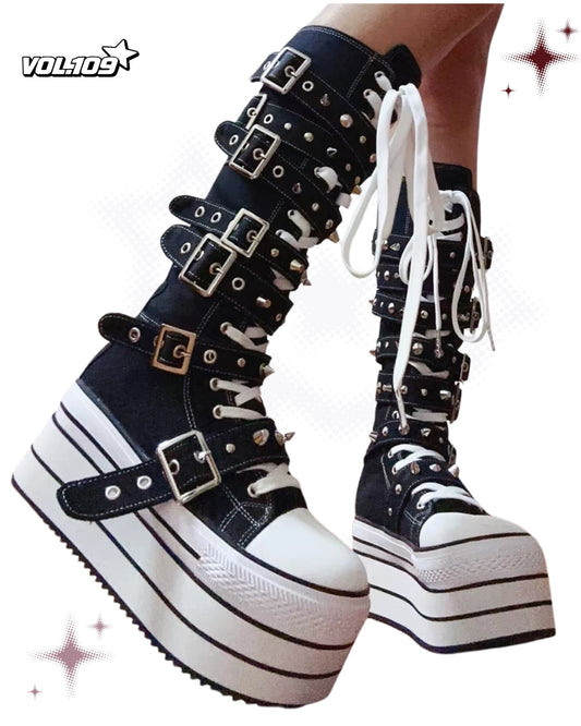 Black and white knee-high platform boots with buckles, spikes and white laces
