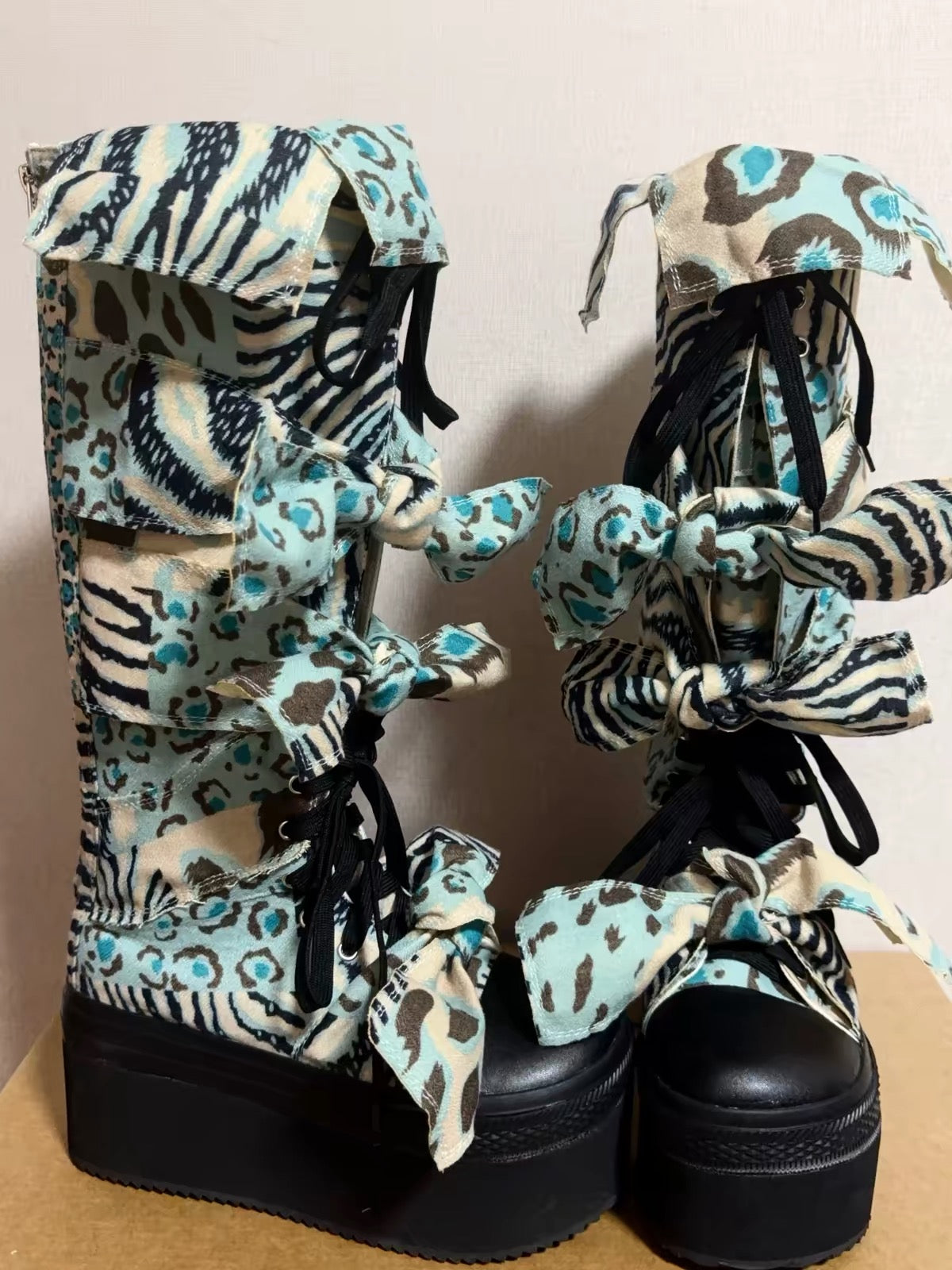 Blue animal print bow platform boots front side view