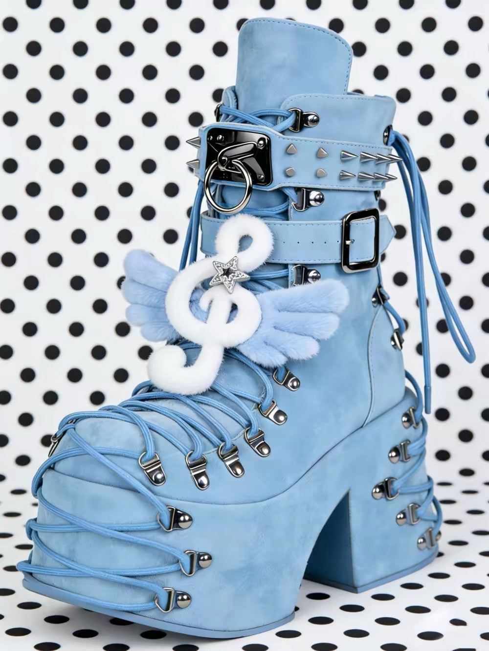 Light blue platform boots with silver hardware, spikes, lacing, and winged music note detail