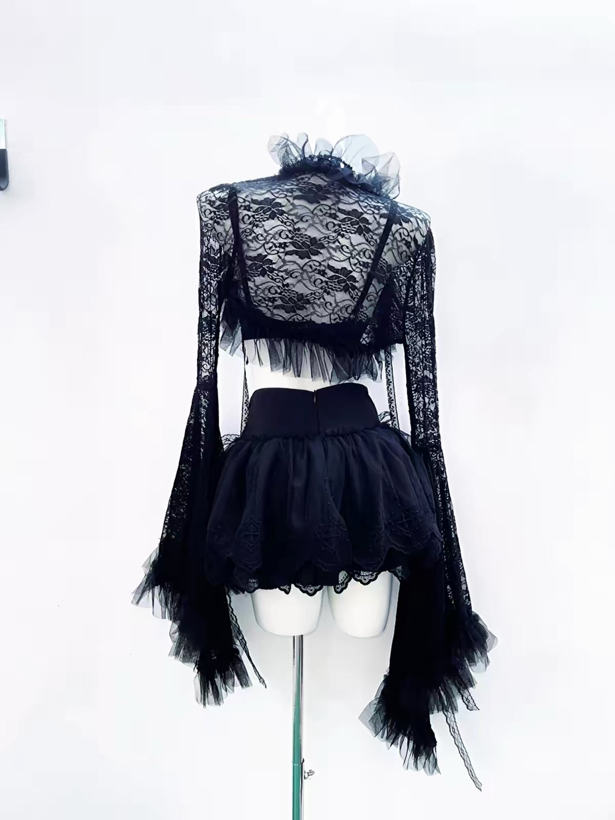 Black cropped lace jacket back view with long flared sleeves and ruffled trim