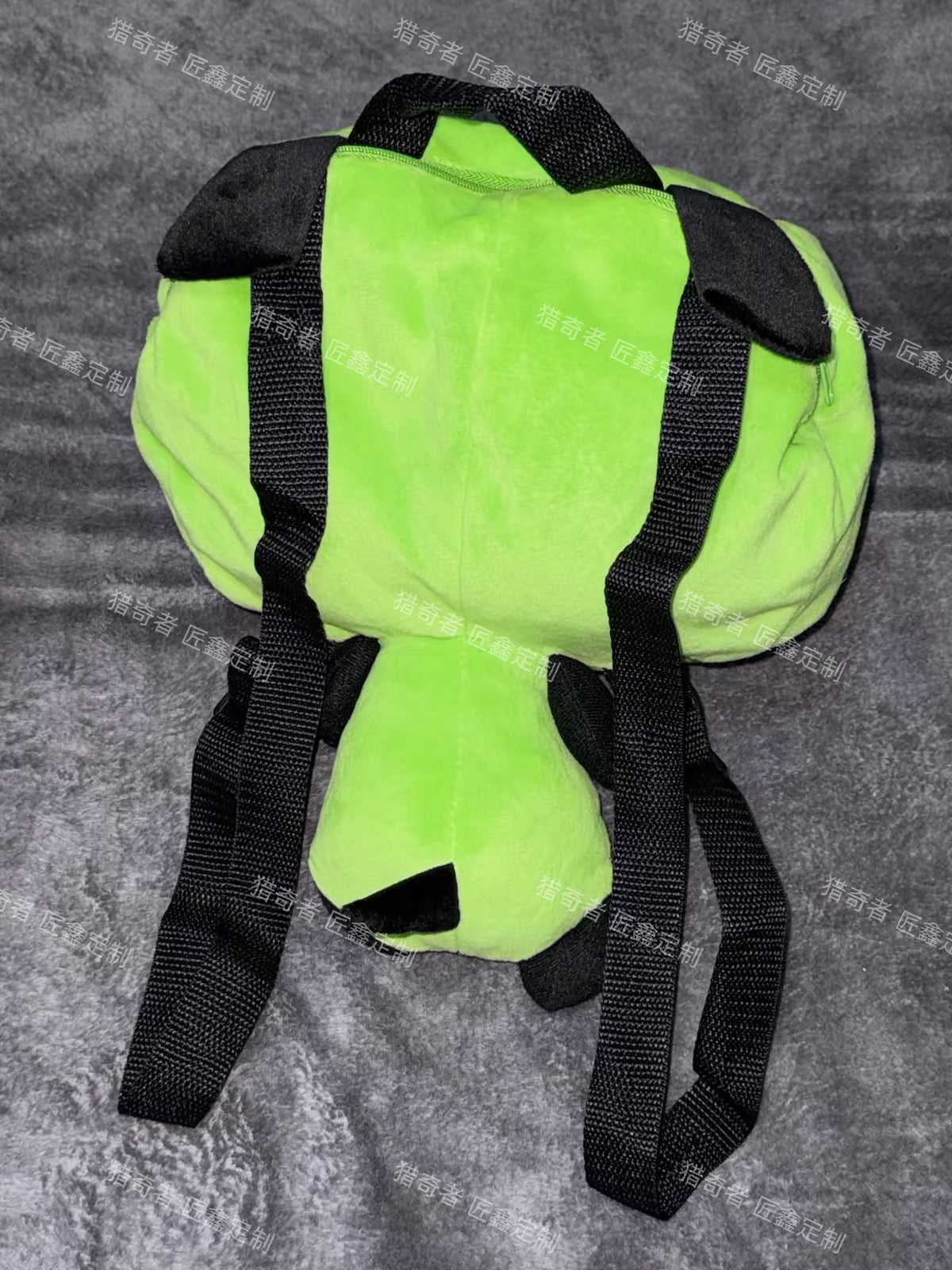 Green plush character backpack back view
