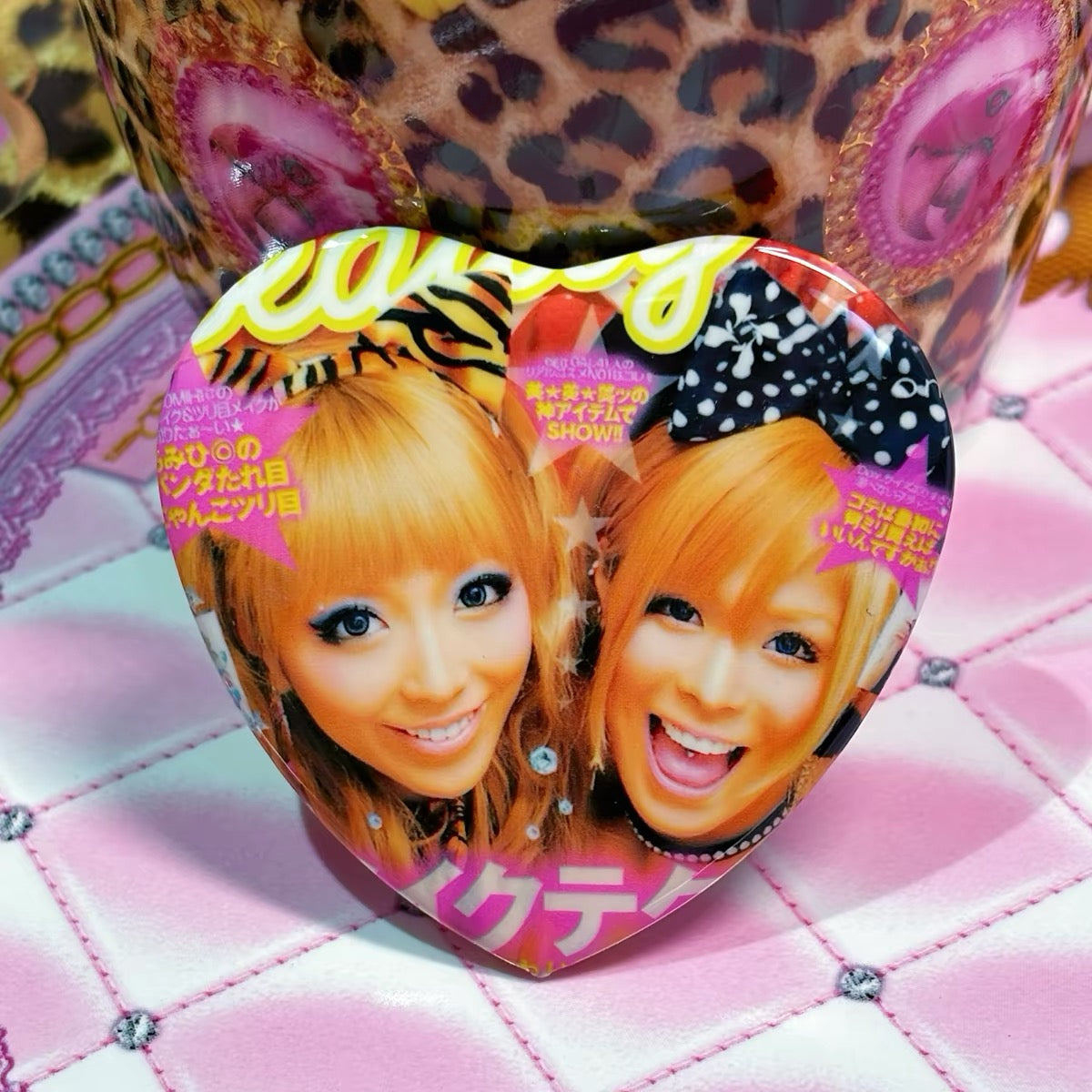 Large heart pin close-up with two gyaru models in yukata styling
