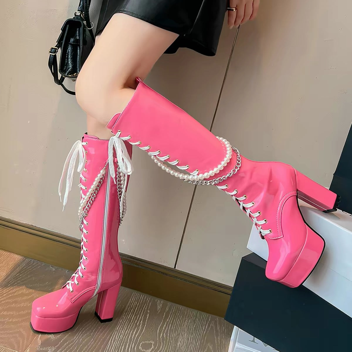 Hot pink knee-high platform boots with pearl and chain details