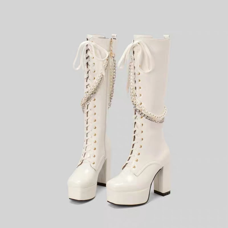 White knee-high platform boots with pearl and chain details
