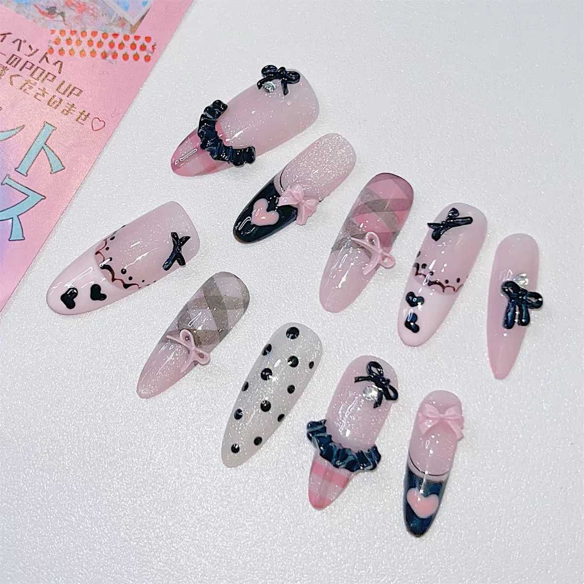 Pink and black bow press-on nails flat lay