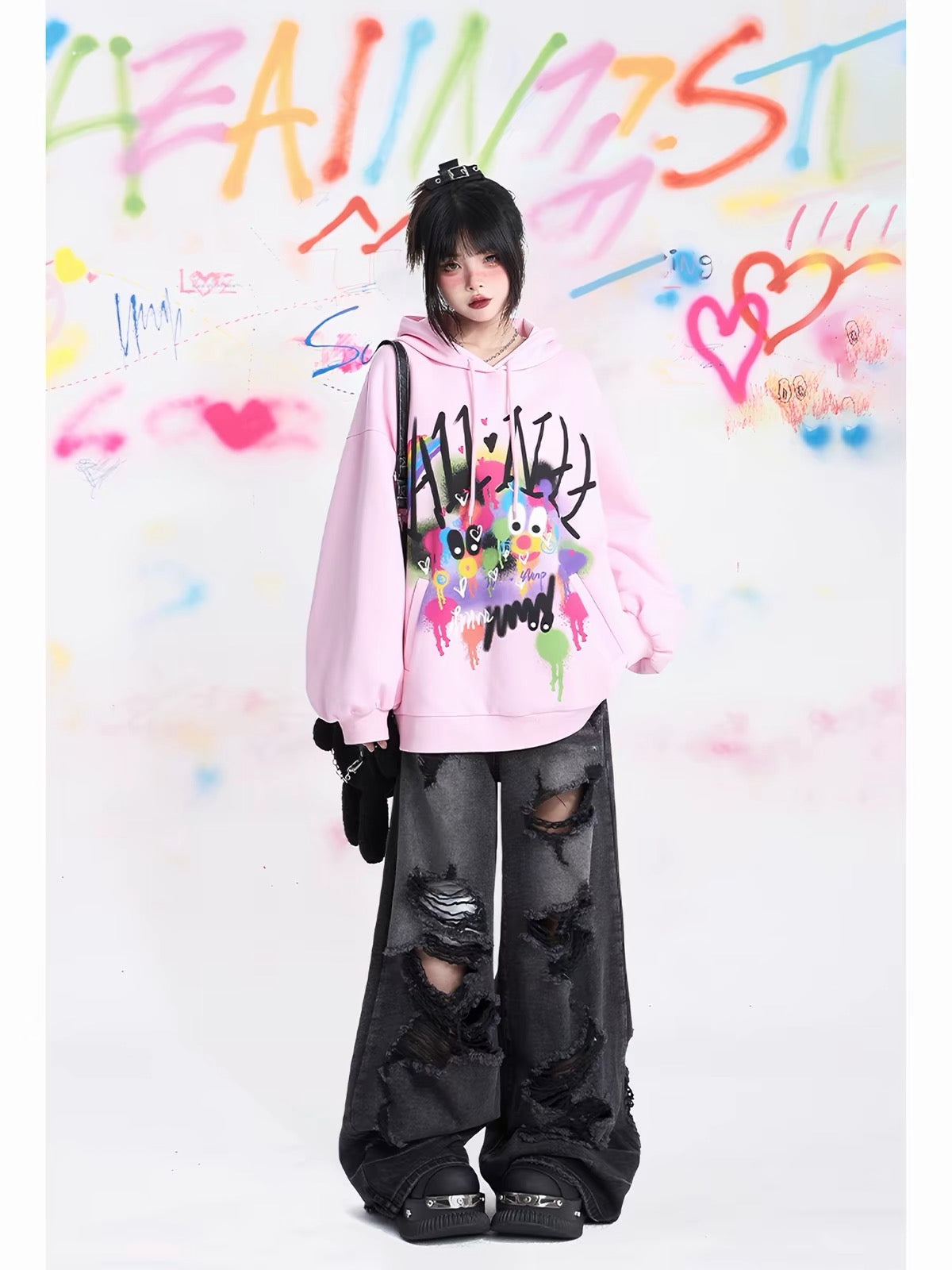 Pink oversized hoodie styled with distressed black pants