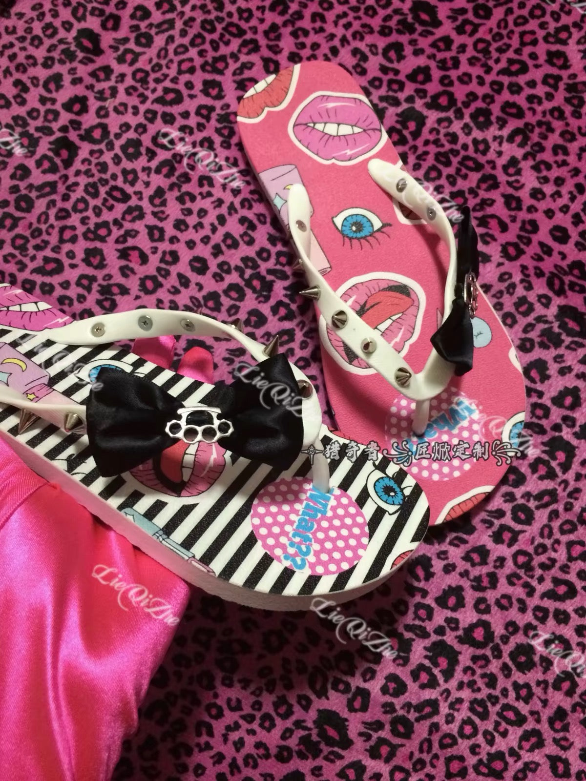 Pink and striped graphic flip-flops with spikes and bow details