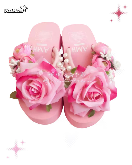 Pink floral platform sandals with large rose decorations and pearl accents
