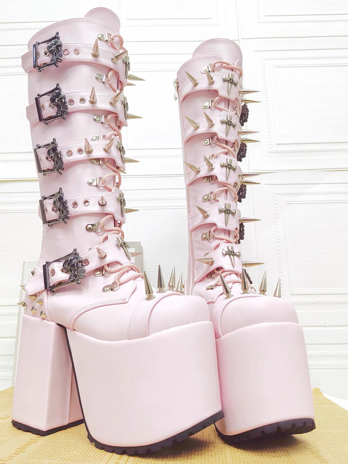 Pink spiked knee-high platform boots front view