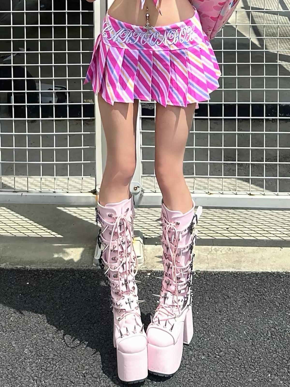 Pink knee-high platform boots styled with a pink skirt