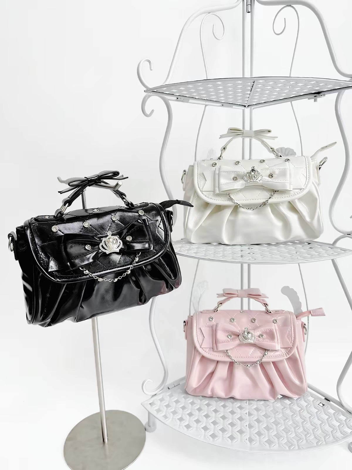 Black, white, and pink bow rhinestone handbags displayed together