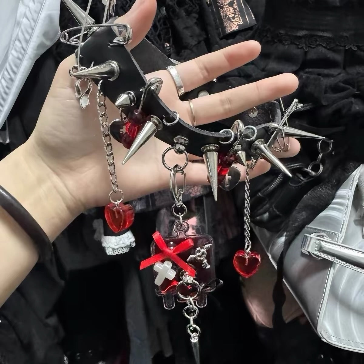 Detail view of black choker with spikes, chains, red hearts and cross charms