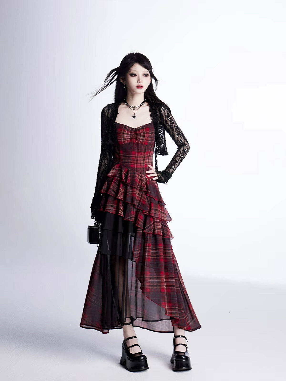 Model wearing red plaid asymmetrical dress with black lace layer