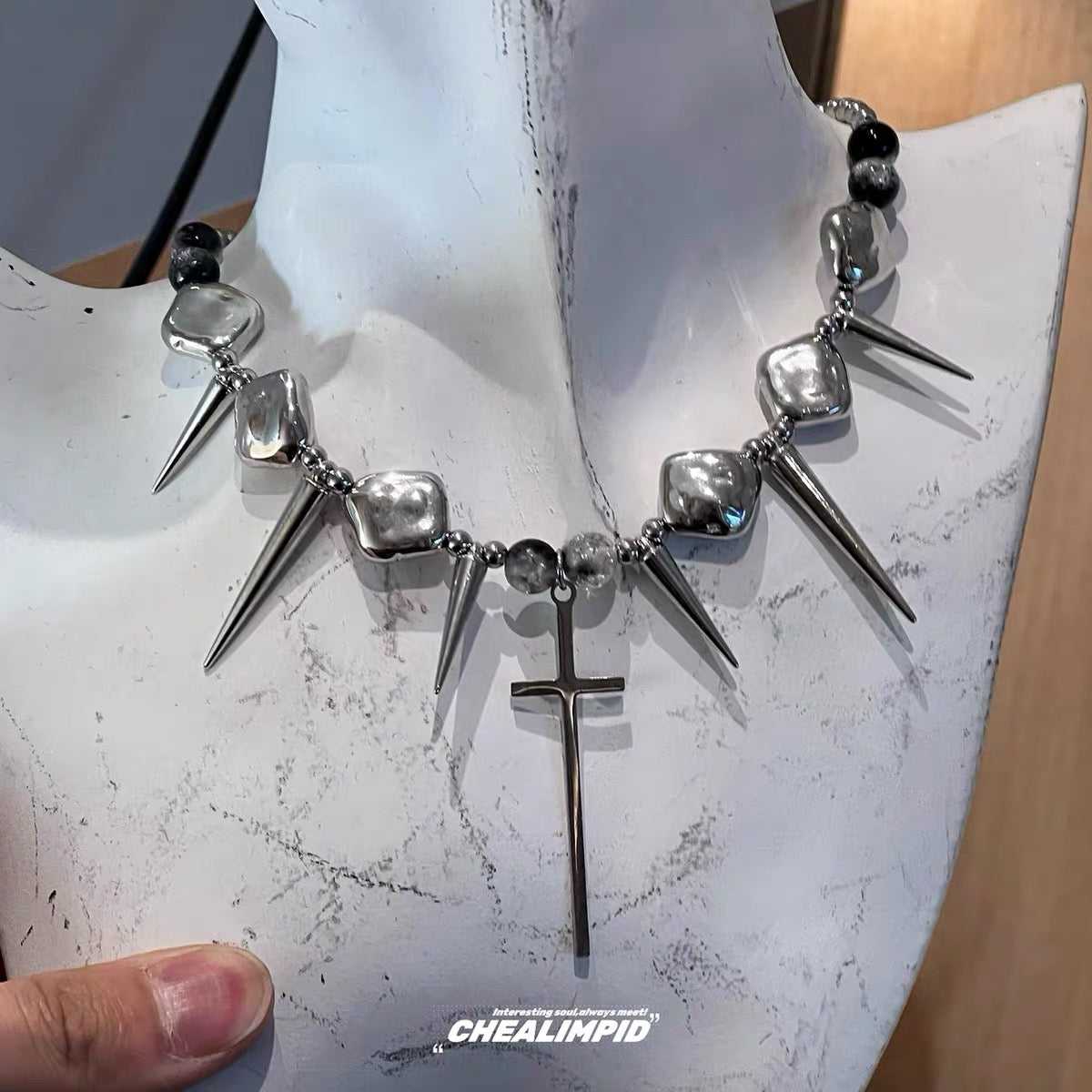 Silver-tone spike and cross necklace detail