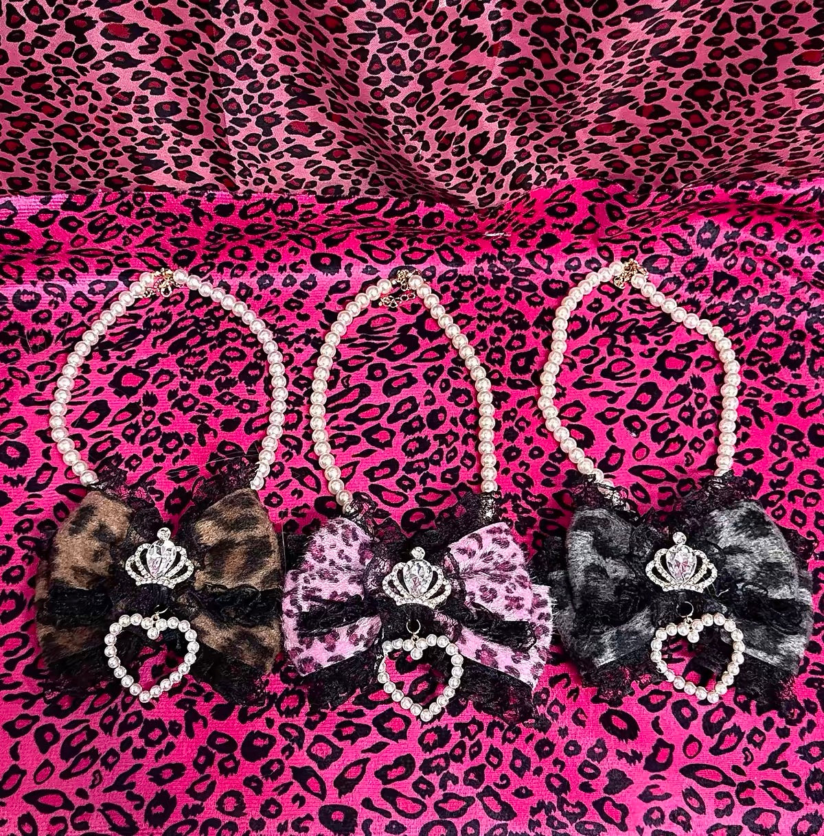 Three leopard bow pearl necklaces in brown, pink, and gray-black colorways