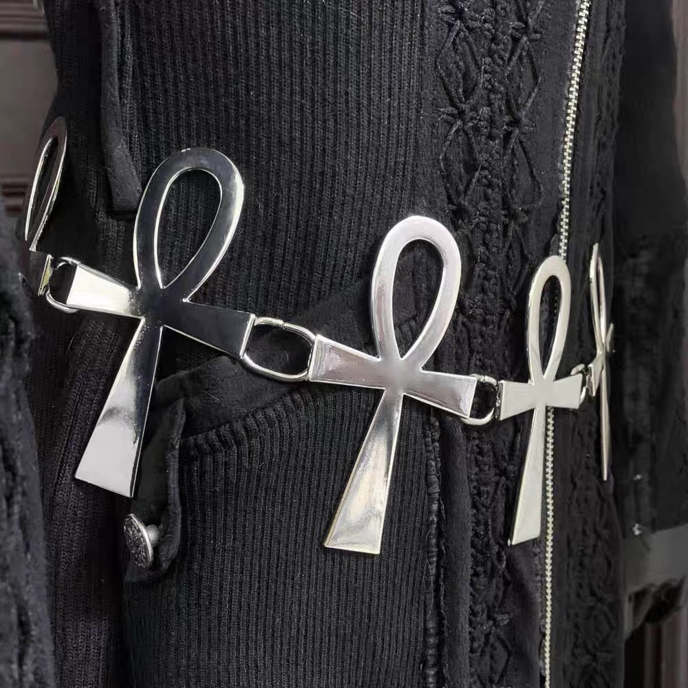 Close-up of polished silver-tone ankh links on the decorative chain belt