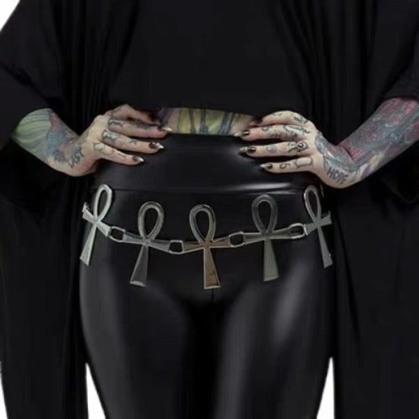 Silver-tone ankh chain belt styled over a black outfit