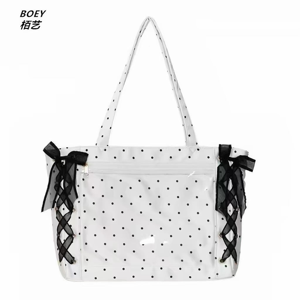 White polka dot ita bag with black lace-up ribbon sides and clear display pocket