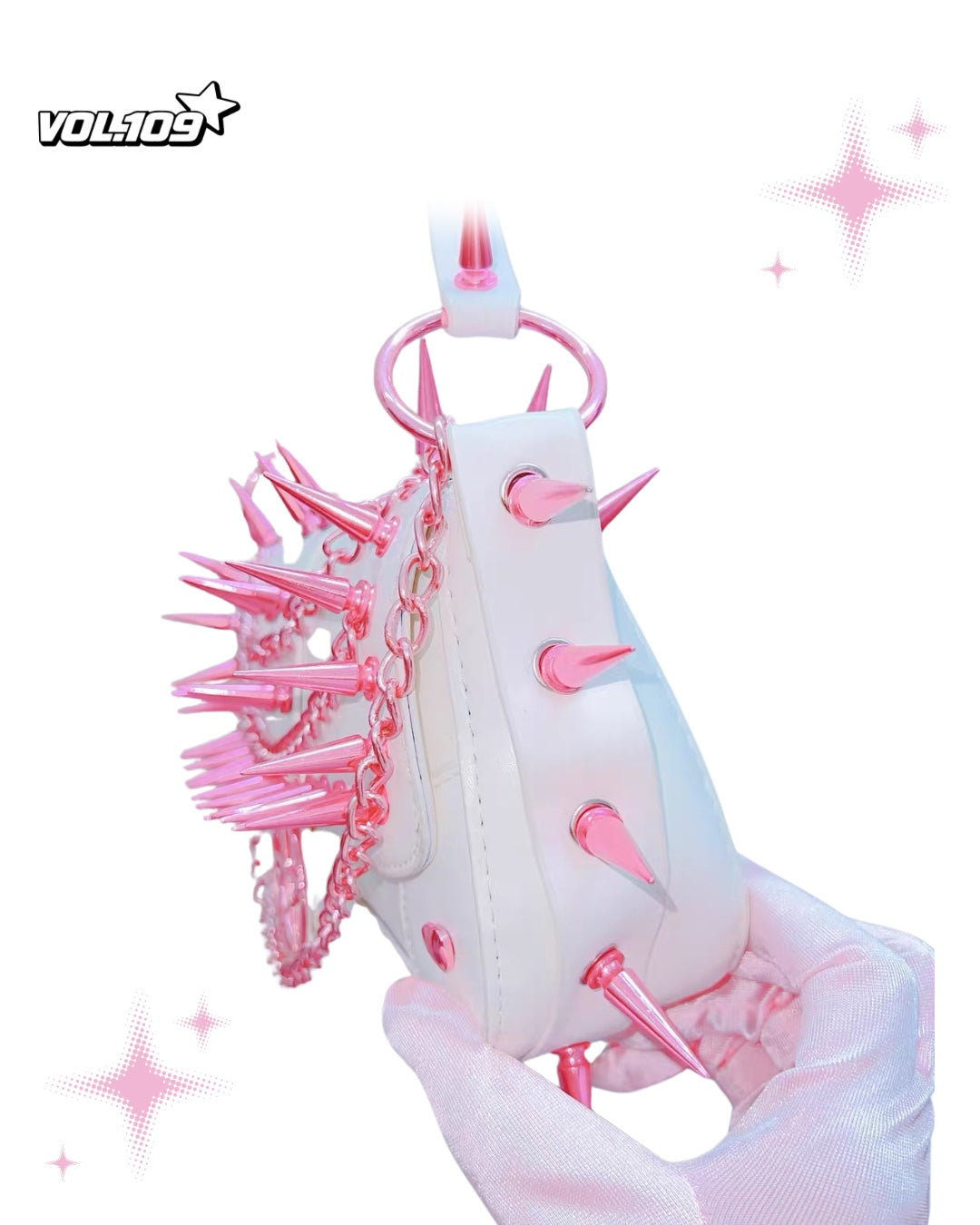 Side view of white shoulder bag with pink spikes and chains