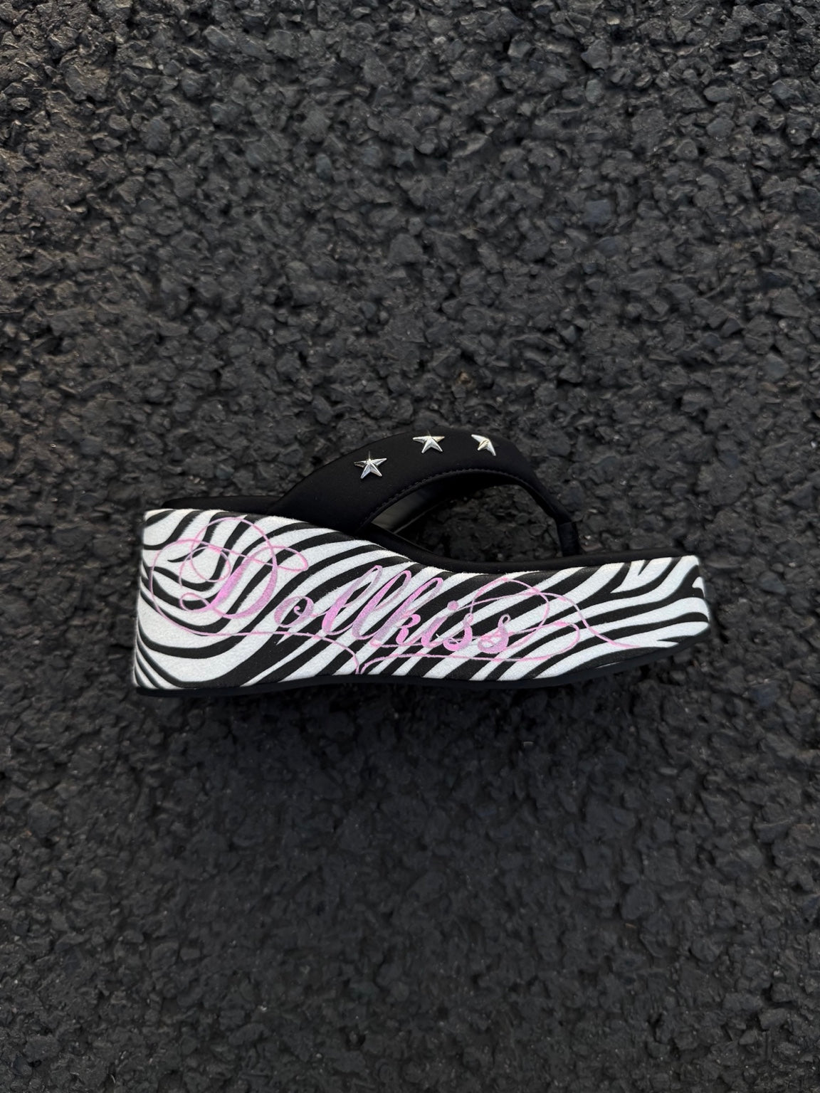 Black zebra platform thong sandals with pink script and silver stars